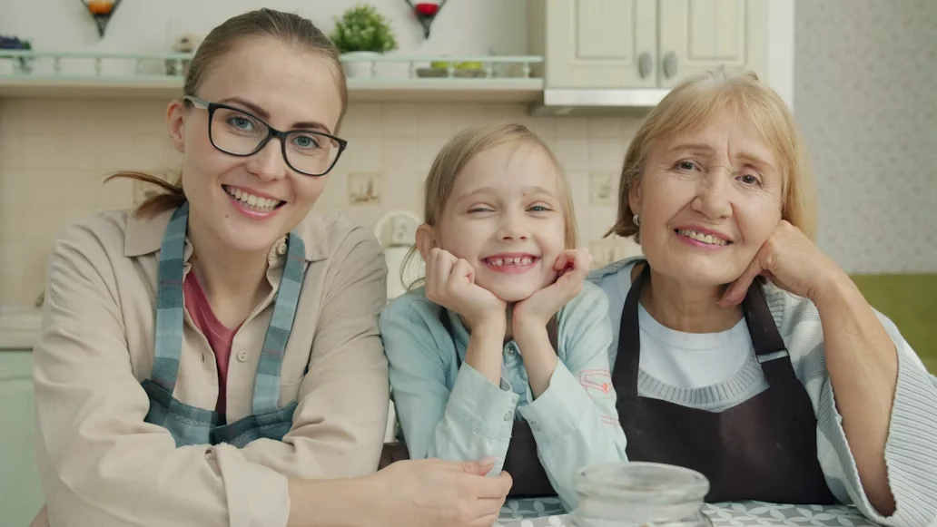 three generations of women smiling in a kitchen