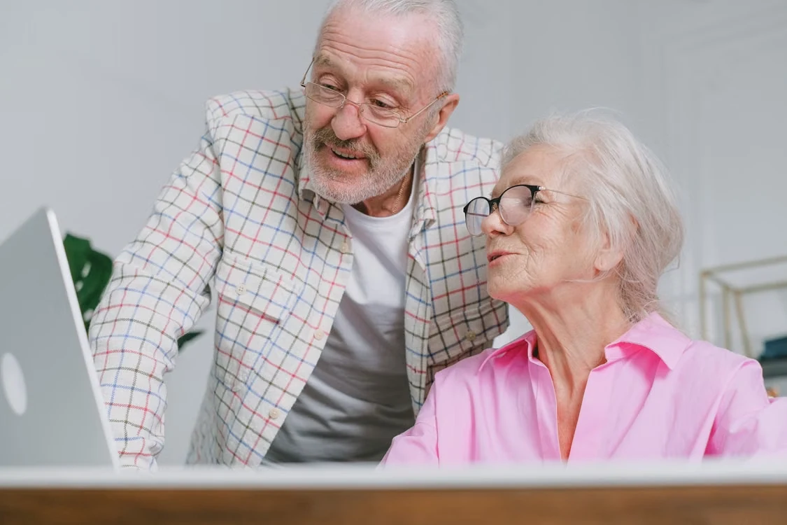 Elderly couple reviewing financial documents together at the kitchen table