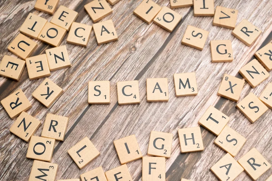 Scrabbled letters arranged to spell “SCAM”