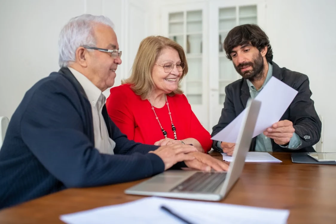 Senior couple discussing retirement insurance options with a consultant in an office setting