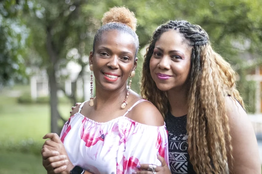 two black women standing together smiling