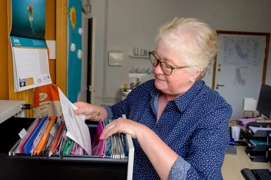An older woman arranging documents