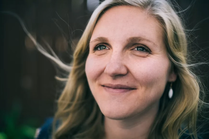 A smiling middle-aged woman with blonde hair