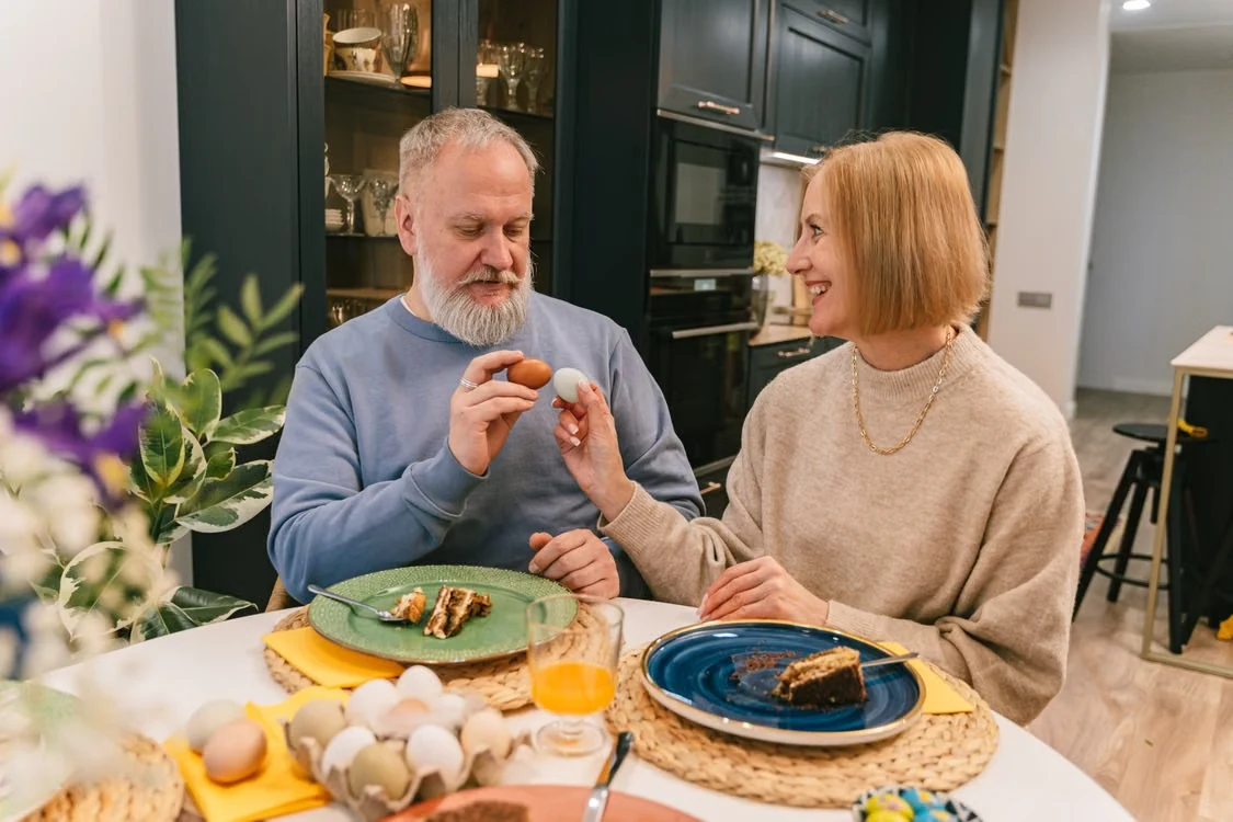 A joyful senior couple sharing a celebratory meal together at a table indoors
