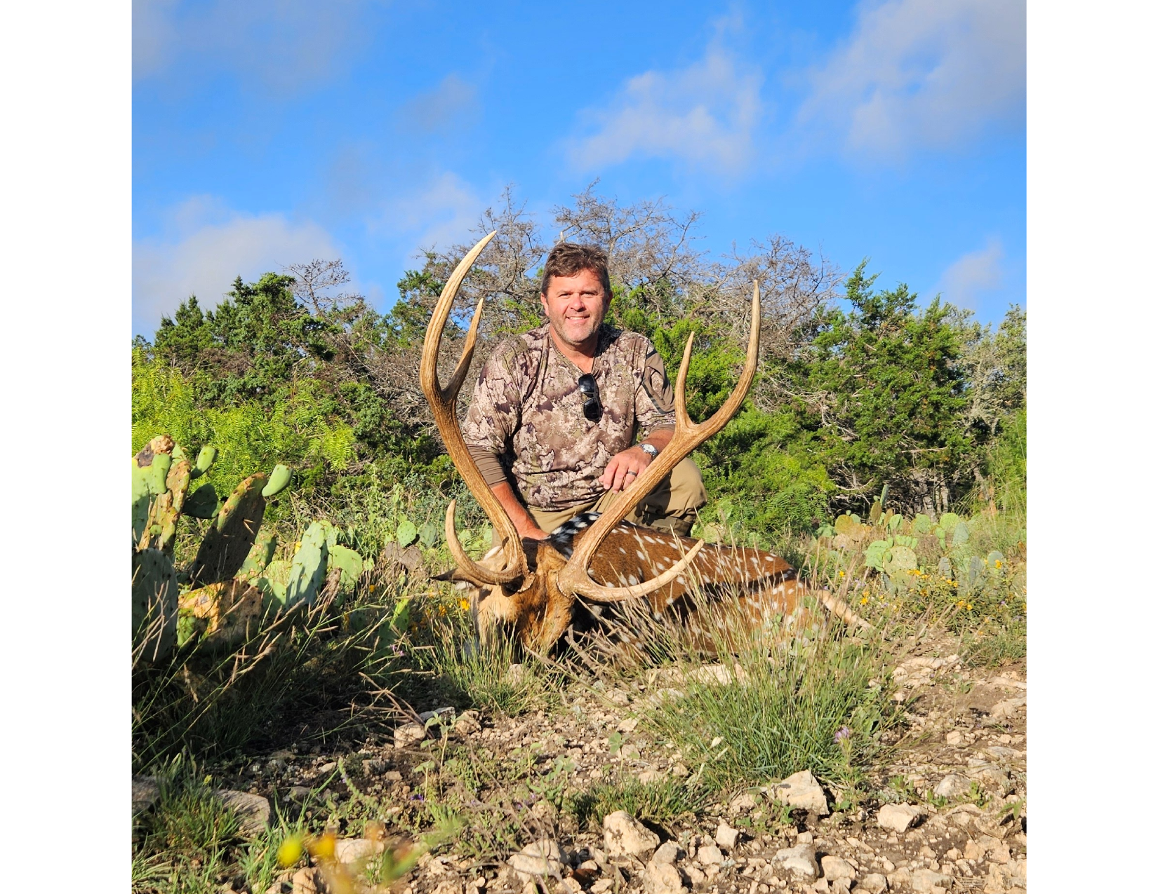 Axis hunter with a mature buck in rocky Sutton County ranch country